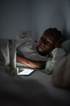 Exhausted woman sleeping in bed with cellphone
