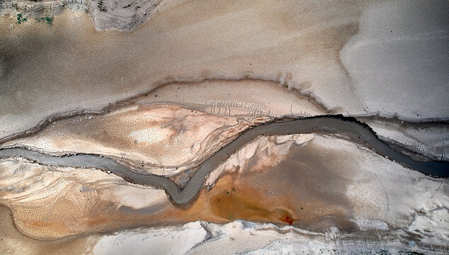 Low water level in dam drained by drought, aerial patterns
