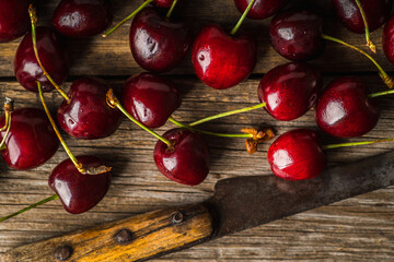 Freshly harvested ripe cherries on the dark rustic background. Selective focus. Shot from above.