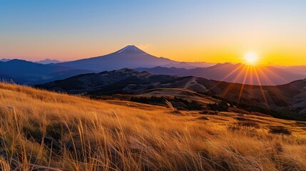 Breathtaking sunrise or setting sun in the mountains with blue clear sky with calm weather and volcano in the horizon - Powered by Adobe