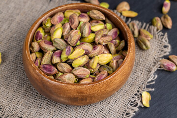 peeled pistachios in a wooden bowl, close-up
