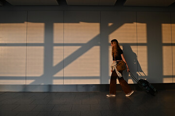 Teenager pulling a suitcase at the airport
