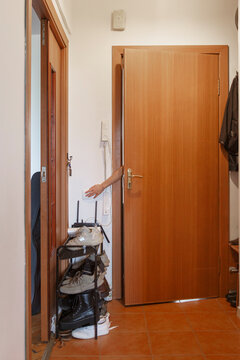 Unrecognizable person standing behind wooden door