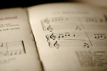 A page from a book with musical notes as a background, close-up view