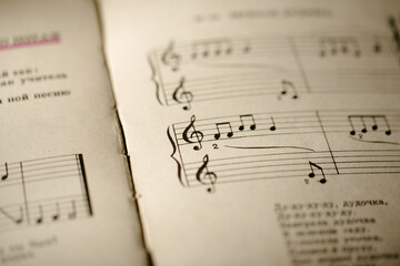 A page from a book with musical notes as a background, close-up view