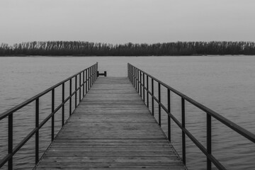 Old jetty, pier on the river. Black and white