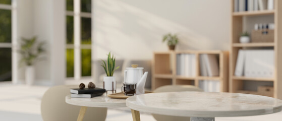 A presentation space on a round marble coffee table in a modern, minimal bright living room.