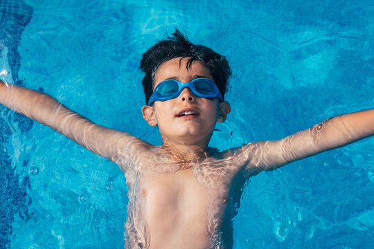 Happy little boy in swimming pool