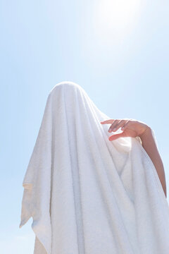 A person playing to be a ghost with white towel 