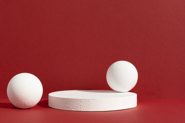 Geometric white podium with balls on an abstract red background. Empty scene for the product...