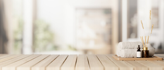 A spa set on a wooden tabletop with a blurred background of a contemporary, spacious bathroom.