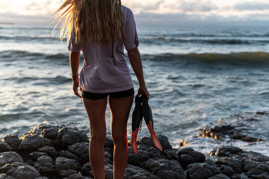 Woman ready for snorkeling holding fins