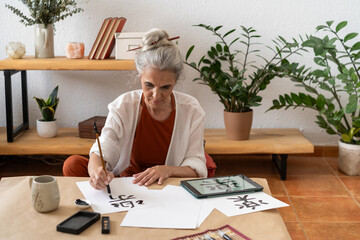 Retired woman painting sumie kanji 