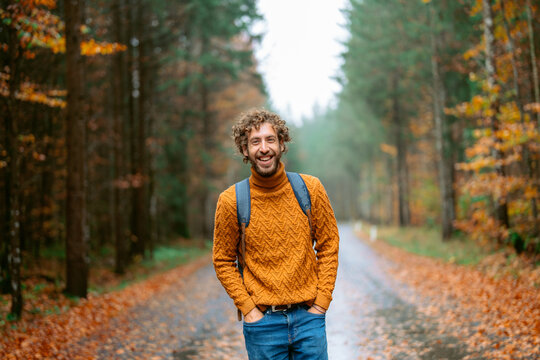 Cheerful man in the forest in autumn after the rain 