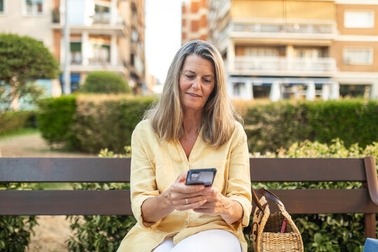 mature woman using mobile phone in the city