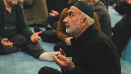 Old Muslim man with a prayer cap praying to Allah at Mosque in Ramadan month