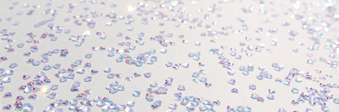 Banner with shiny silver crystal confetti on a blue background. Selective focus.