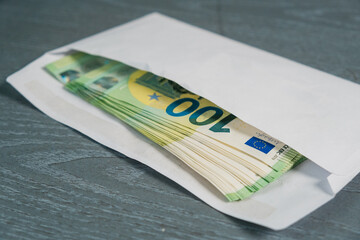 Close-up of money in an envelope. Concept of bribe, corruption, salary, earnings and financial...