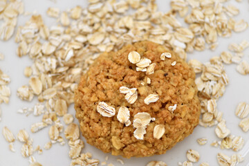 Oatmeal cookies with oat flakes on a white plate. Healthy food for breakfast or a snack. Close up. Soft focus