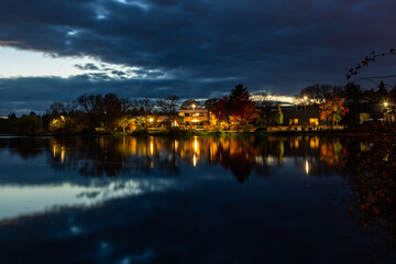 Fototapeta na wymiar Lights reflection in an autumn pond at dusk. Beaverton, Oregon