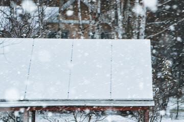 Solar panels are covered with snow in winter. Photovoltaic electricity installation during the winter season. Alternative energy home production in cold weather.