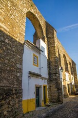 Traditional house under a roman aqueduct in Evora, Portugal