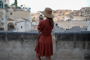 Female tourist taking mobile phone photosin Matera 
