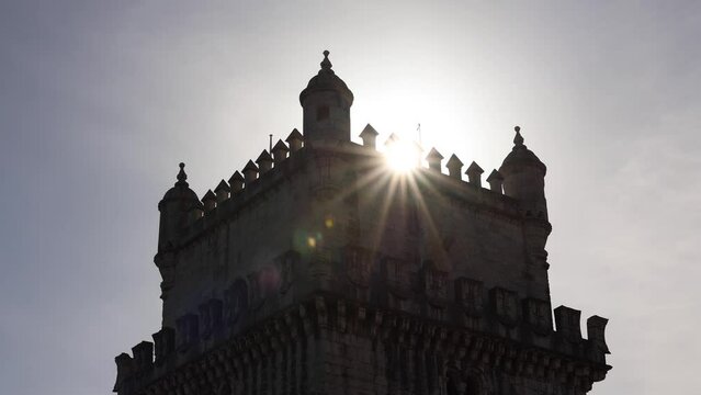 Sun over Belem Tower in Lisbon. 4K video with this medieval fortified landmark tower with star sun rising over it. Landscape video of Portugal.