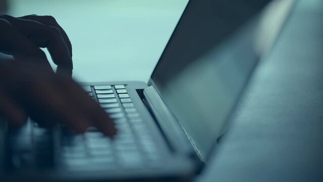 Businessman hands type on laptop keyboard business 4K Hands touch typing on laptop notebook keyboard sit at home office desk working online. Technology and business concept close up side view.