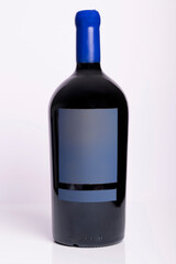 An imperial Bordeaux bottle contains red wine on a white background