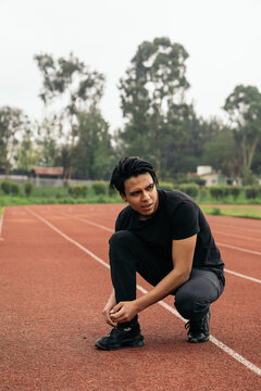 Young man in the park tying his shoelaces.