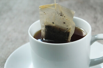 close up of a cup of hot tea and a tea bag