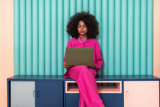 Focused Freelancer in Pink with Teal Backdrop