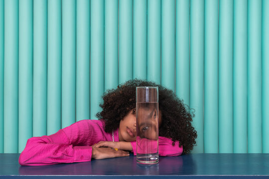 Curious Gaze Through Glass: Woman in Pink with Water