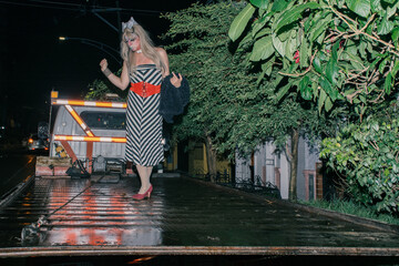 Queer man does catwalk on top of a trolley crane