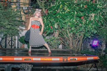 Queer man poses on top of a trolley crane