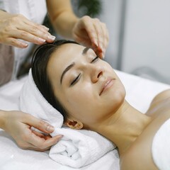 Fototapeta na wymiar Relaxed woman at beauty treatment salon. She getting body and face hot towel therapy