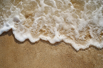 Detailed view of a wave rolling onto a sandy beach, highlighting the power and movement of the water meeting the shore
