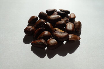 Close shot of heap of hard dark brown bean-like glossy seeds of cherimoya