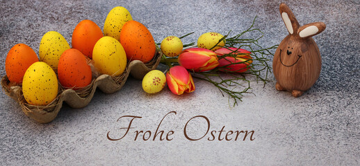 Grußkarte Frohe Ostern: Dekoration mit Osterhase, bunten Ostereiern und dem Text Frohe Ostern. 