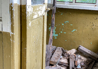 Abandoned blue door with chipped paint and a worn metal handle