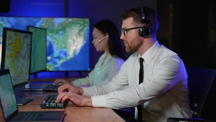 Tired stressed delivery transport dispatcher operator removes headphones after a hard working day in control room