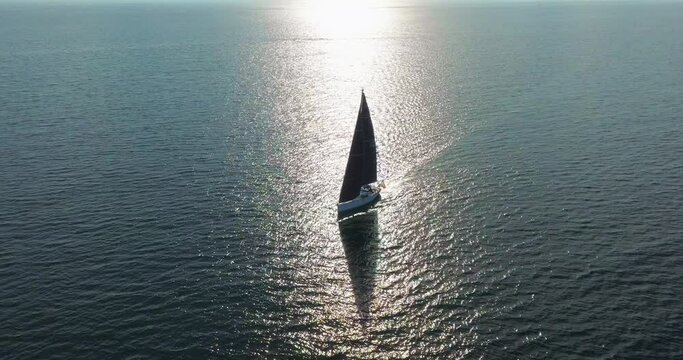 Aerial view a luxury yacht at sunset. Big sailing yacht boat driving on the ocean on a sunny day