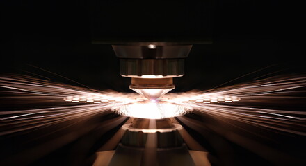 Laser cutting of metal sheet in production closeup. Sparks fly out machine head for metal processing