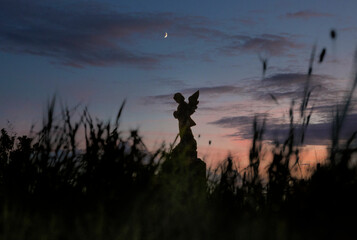 Statue of an angel at sunset. Graveyard. Tombstones. Nineties. Dorset. England UK. 