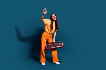 Foto op Aluminium Full body length photo of cool dancer professional dj entertainer girl raised palm up hold boombox isolated on dark blue color background © deagreez