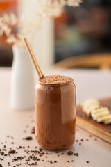 Chocolate smoothie on a coffee shop table, with sliced bananas on the side. Vegan smoothie, healthy...