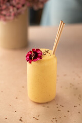 Mango smoothie on a coffee shop table. Vegan smoothie, healthy drink. Side view.
