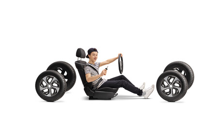 Male teenage driver in a car seat holding keys and steering wheel