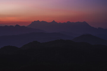 Fototapeta premium nature traveling with orange sky and layer of mountain with sunrise background
